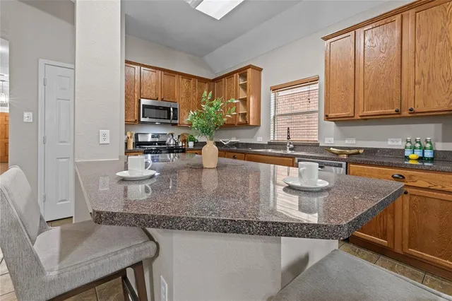 a kitchen with granite countertop a sink a stove and cabinets