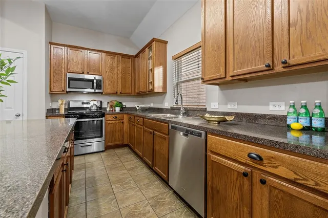 a kitchen with stainless steel appliances granite countertop a stove a sink and a microwave