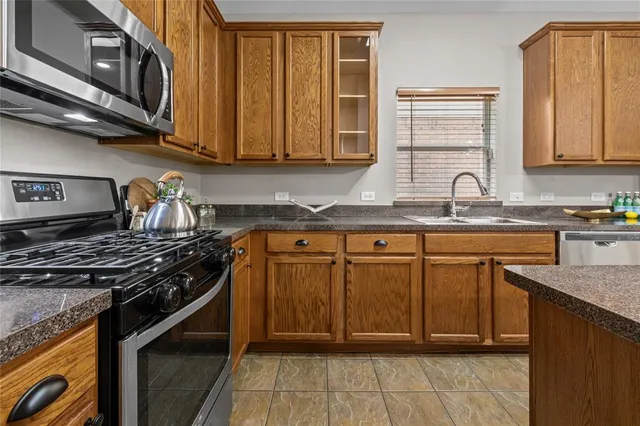 a kitchen with stainless steel appliances granite countertop a sink stove and cabinets