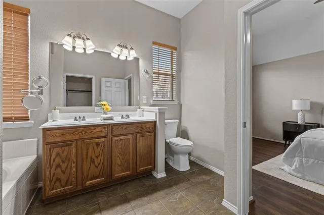 an empty room with wooden floor cabinet and windows