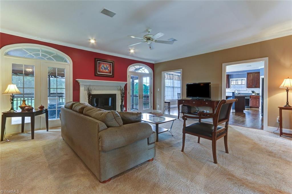 5203 Red Fox Drive Oak Ridge, NC 27310 - Photo 7 of 30 Centrally located in the home is your main gathering room with fireplace and transomed windows and doors that lead to the screen porch.