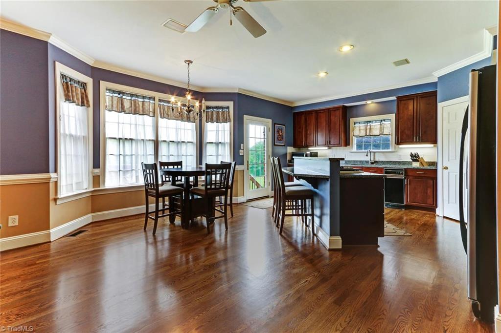 5203 Red Fox Drive Oak Ridge, NC 27310 - Photo 10 of 30 Slip from the great room into the huge kitchen, bar, and breakfast area with easy access to the deck and a beautiful view of the lake.