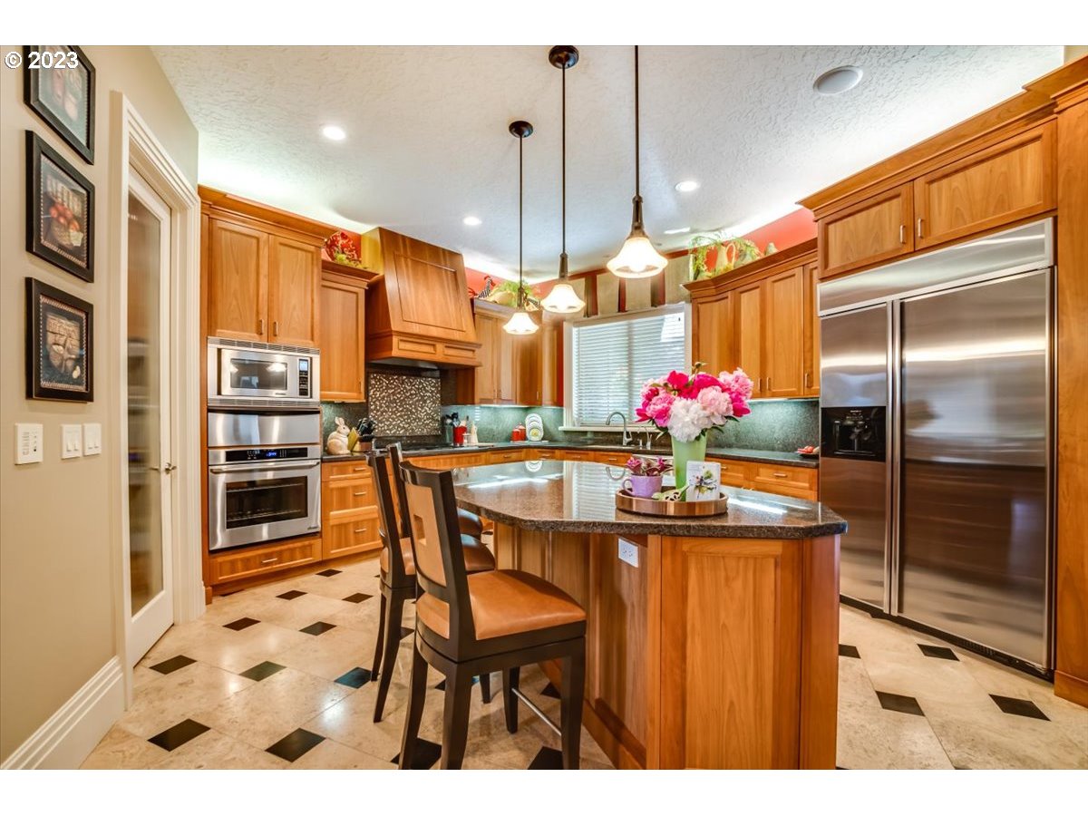 1531 Southeast 26th Drive Gresham, OR 97080 - Photo 20 of 44 a kitchen with stainless steel appliances kitchen island granite countertop a refrigerator and a sink