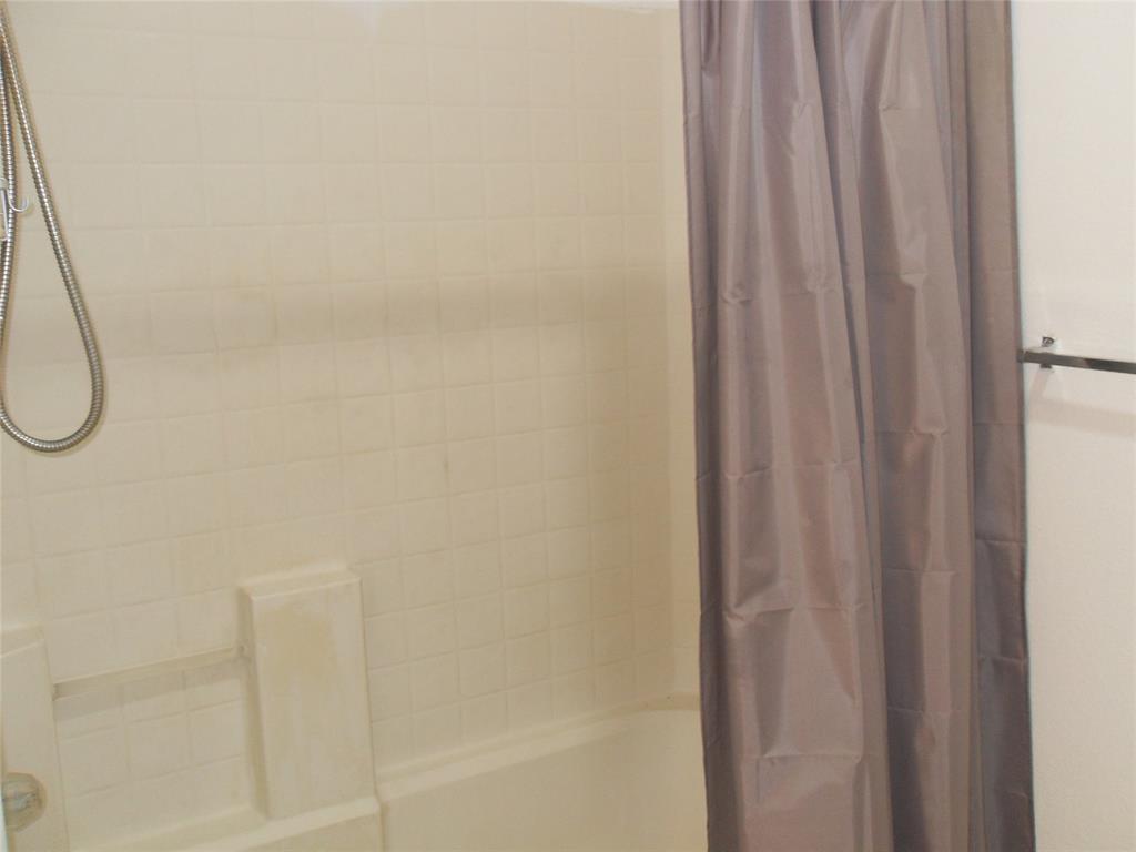 817 Cruise Street Denton, TX 76207 - Photo 12 of 13 a bathroom with a shower curtain and a window