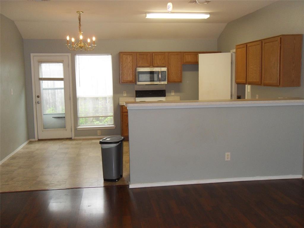 817 Cruise Street Denton, TX 76207 - Photo 3 of 13 a view of a kitchen with wooden floor and electronic appliances