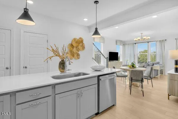 a kitchen with stainless steel appliances a dining table chairs and a wooden floor