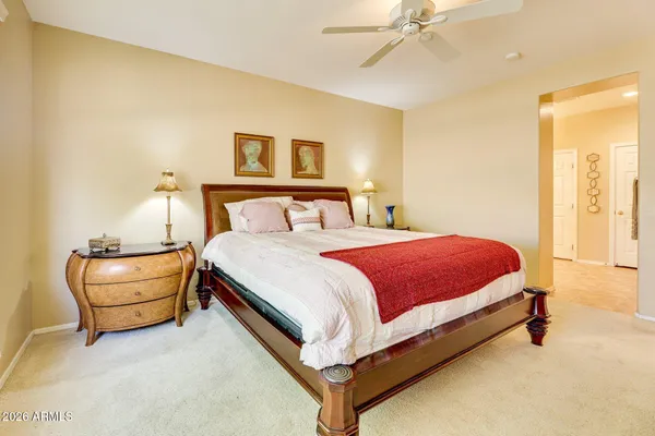 a spacious bedroom with a bed and ceiling fan