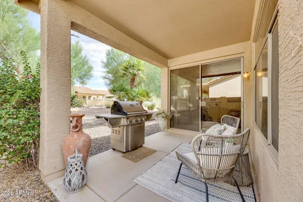a living room with patio furniture and a potted plant