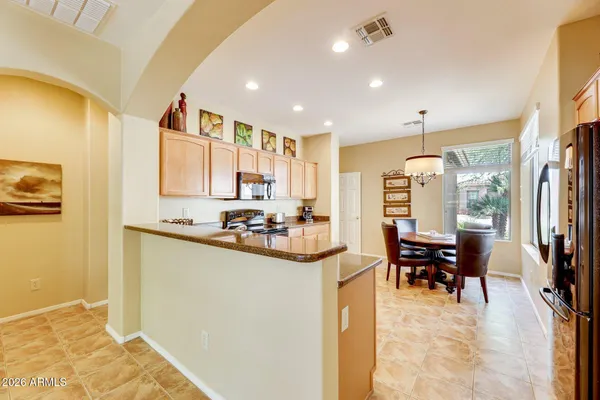 a kitchen with stainless steel appliances kitchen island granite countertop a refrigerator and cabinets