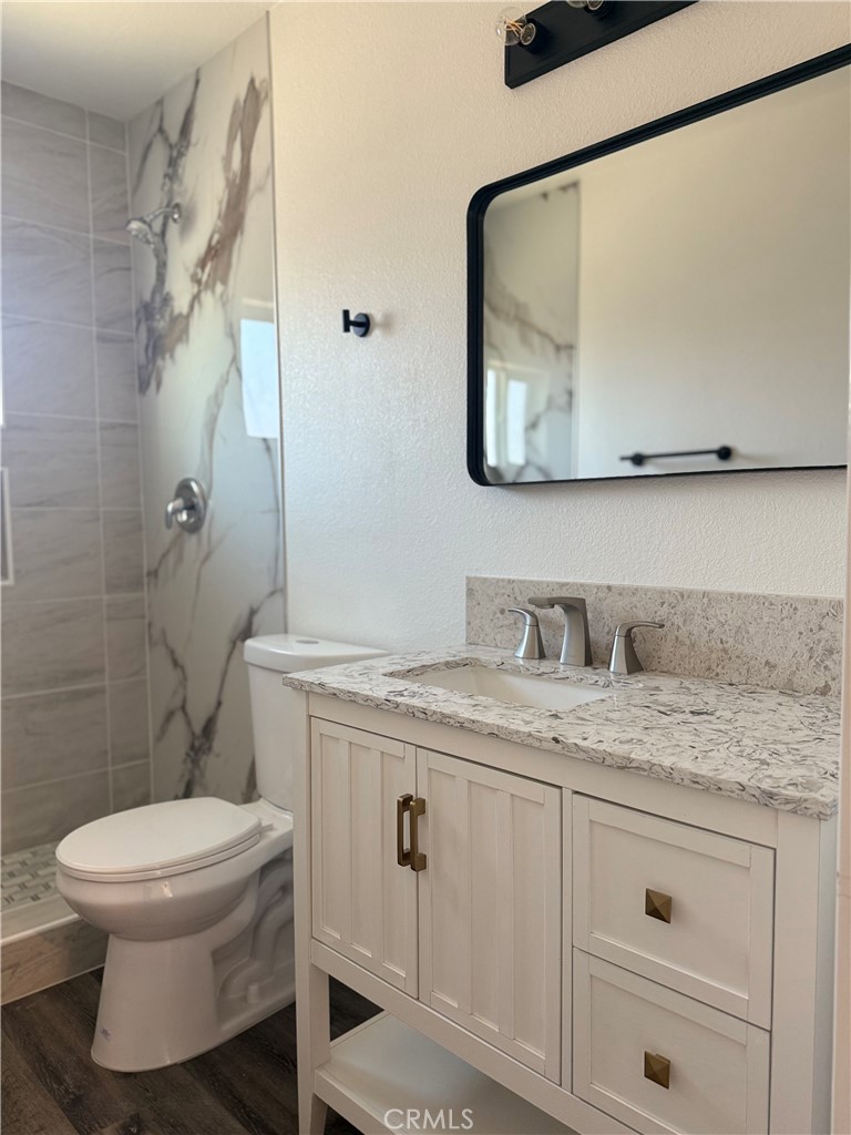 880 South State Street Hemet, CA 92543 - Photo 19 of 21 a bathroom with a granite countertop sink toilet and a mirror