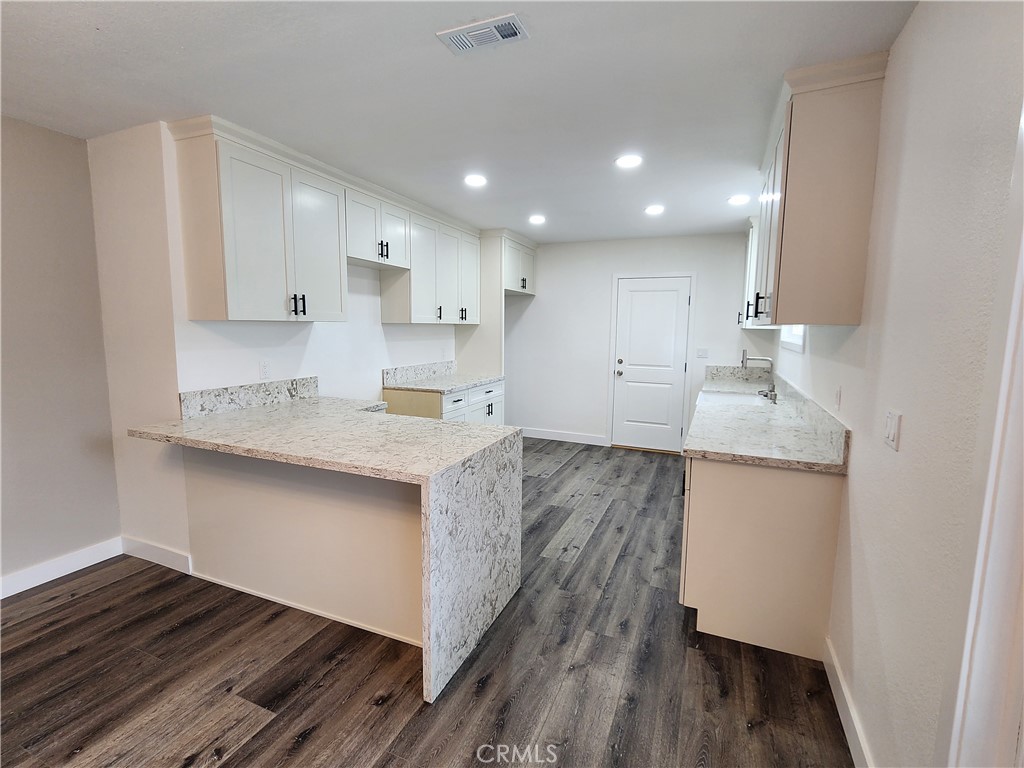 880 South State Street Hemet, CA 92543 - Photo 8 of 21 a kitchen with granite countertop white cabinets and wooden floor