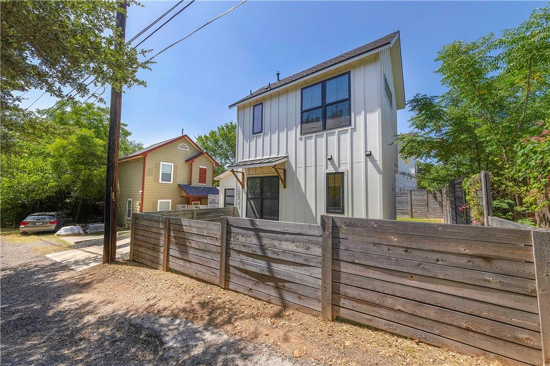 2002 East 9th Street, Unit 2 Austin, TX 78702 - Photo 27 of 32 A striking modern facade with ample fenestration rises above a robust wooden privacy fence.