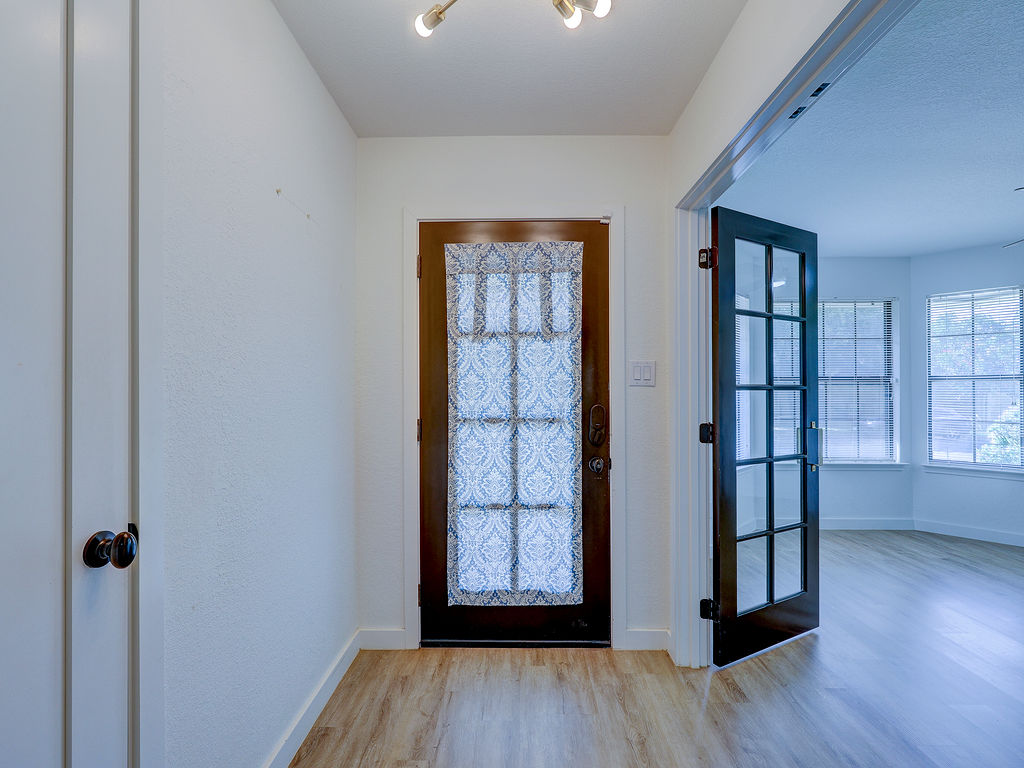 5842 Secrest Drive Austin, TX 78759 - Photo 9 of 40 A welcoming entryway with a glass-paned door, leading to a sunlit living space.