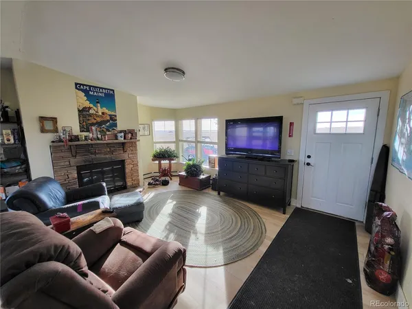 a living room with furniture a flat screen tv and a fireplace