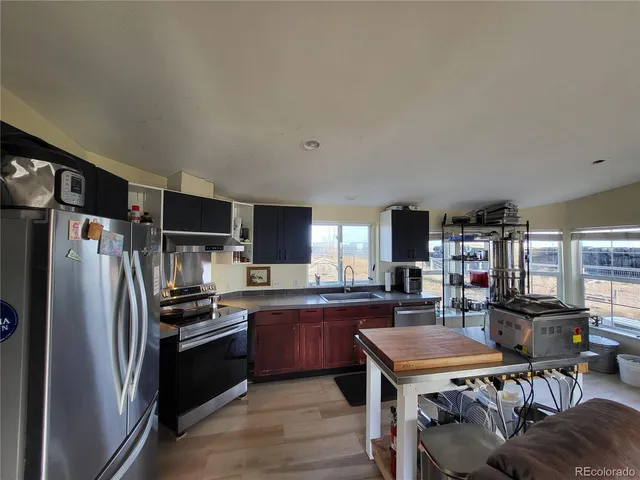 a kitchen with stainless steel appliances granite countertop a refrigerator stove microwave and sink