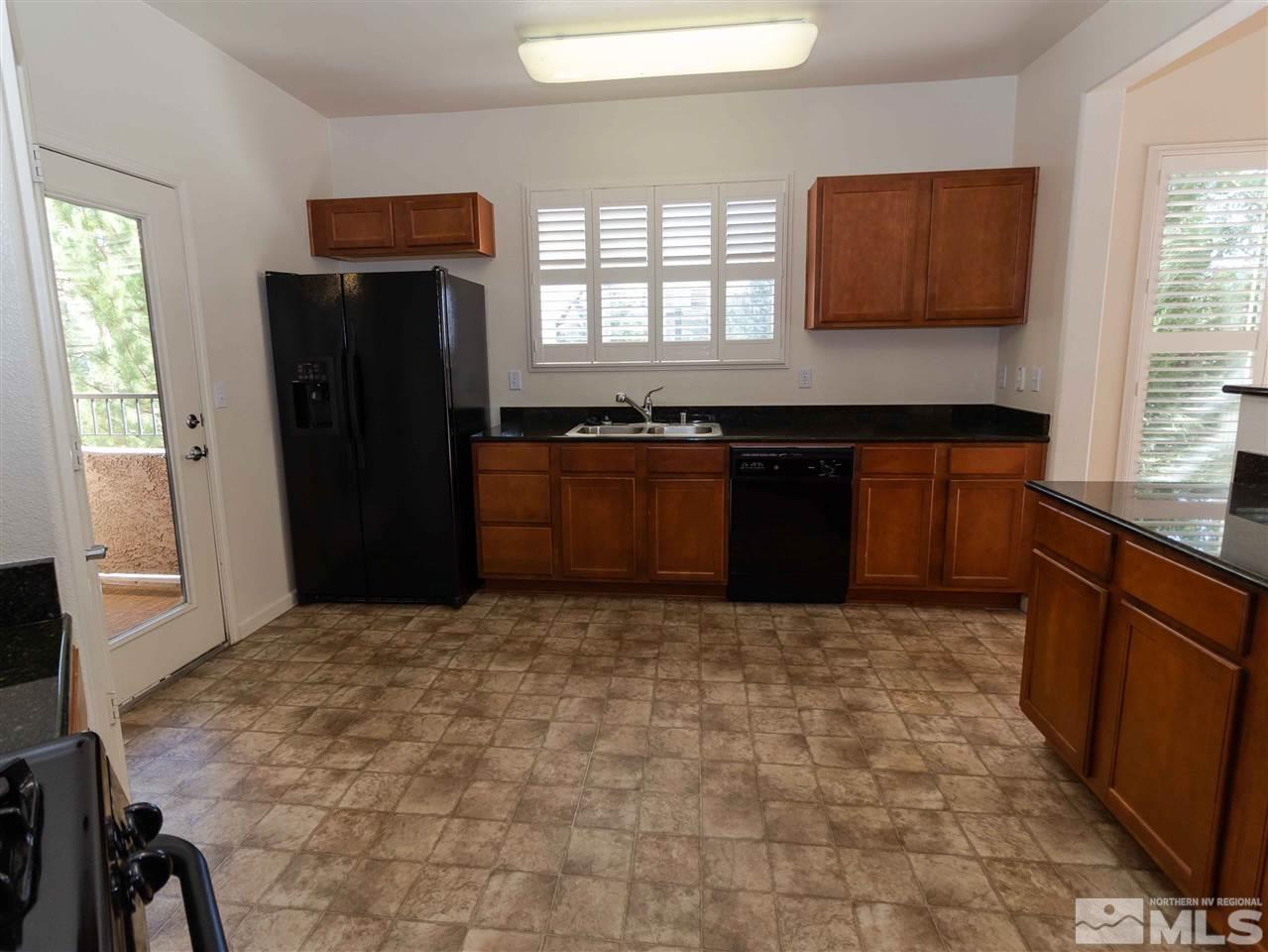 9050 Double R, Unit 1925 Reno, NV 89521 - Photo 5 of 25 a kitchen with granite countertop a refrigerator and a stove top oven