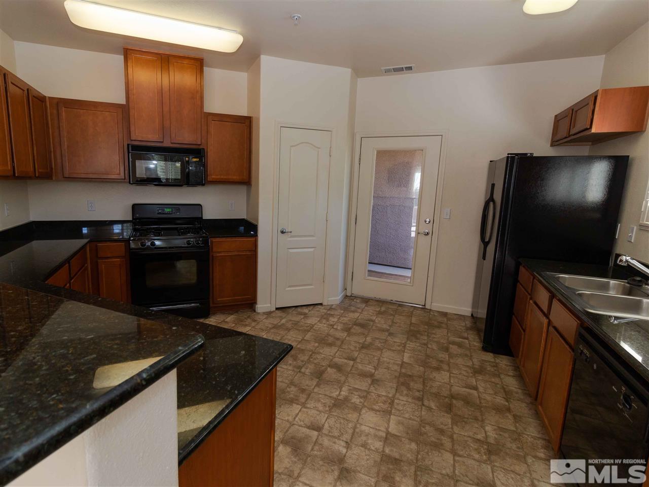 9050 Double R, Unit 1925 Reno, NV 89521 - Photo 7 of 25 a kitchen with granite countertop a stove and a refrigerator