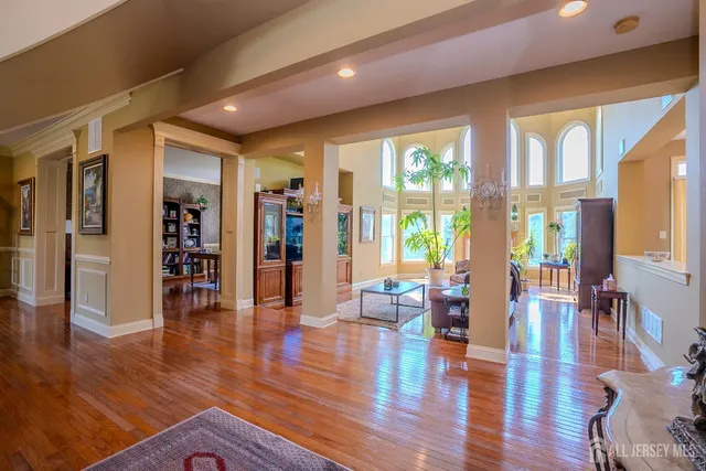 a kitchen with stainless steel appliances granite countertop wooden cabinets a refrigerator a sink a stove and a wooden floors