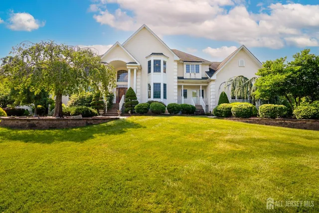 a front view of a house with a yard and trees