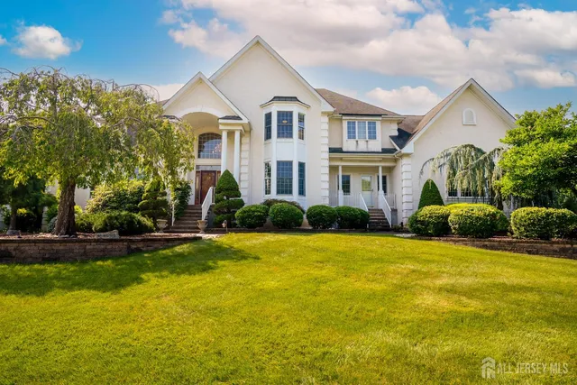 a view of a house with a yard and palm trees