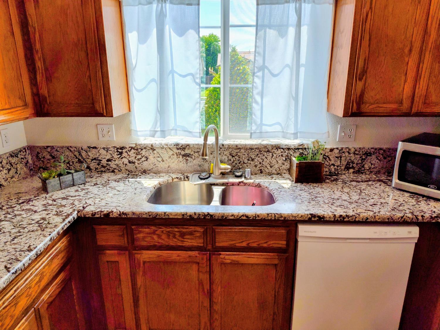 2846 Edgar Avenue Sanger, CA 93657 - Photo 7 of 25 a kitchen with granite countertop cabinets sink and window