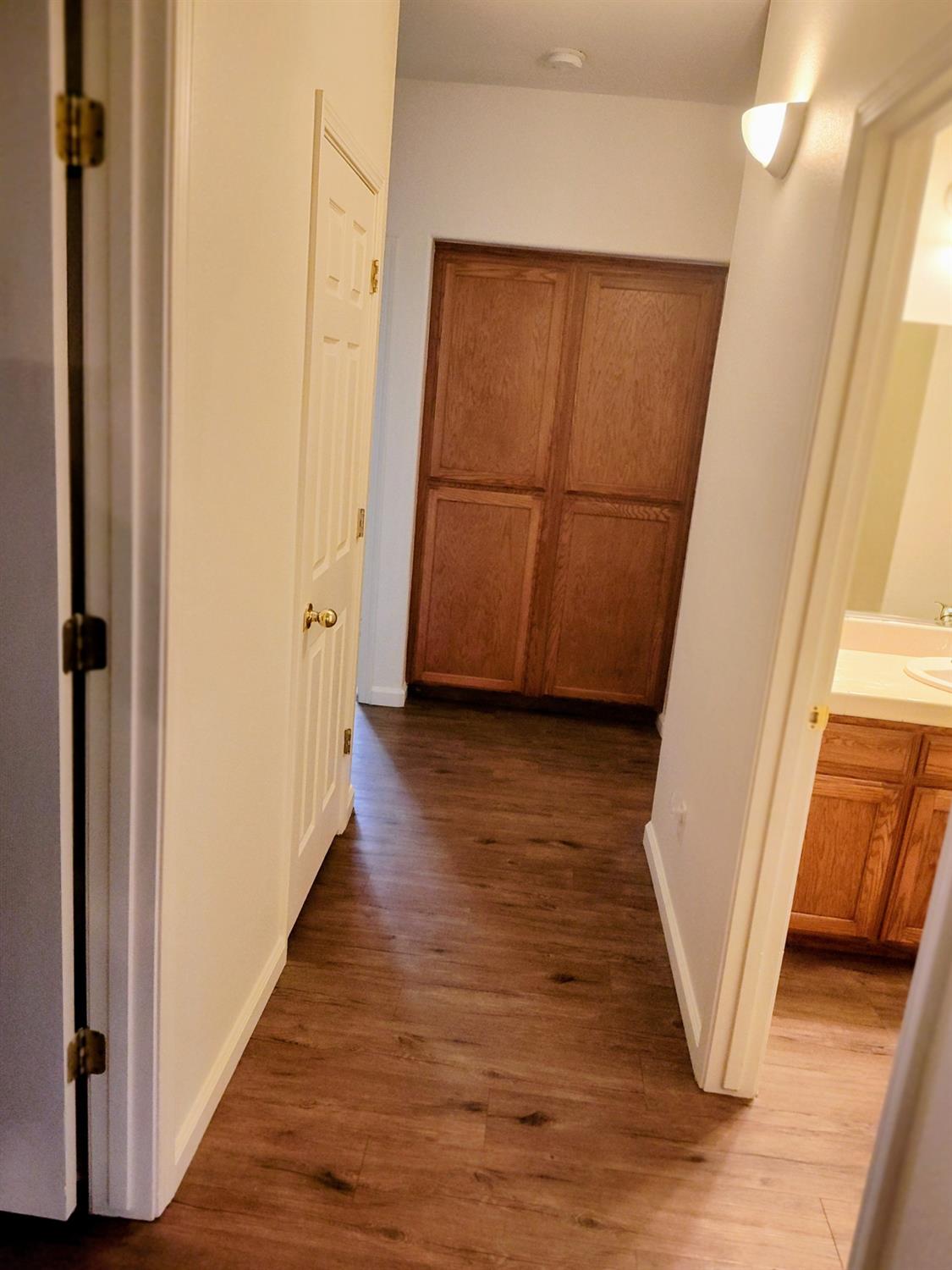 2846 Edgar Avenue Sanger, CA 93657 - Photo 9 of 25 a view of a hallway with wooden floor and stairs