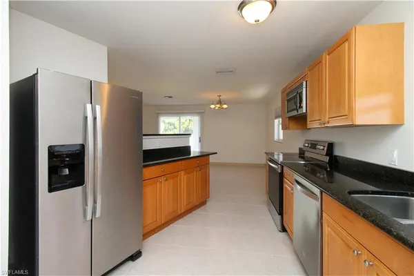 a kitchen with stainless steel appliances granite countertop a refrigerator a sink and a stove