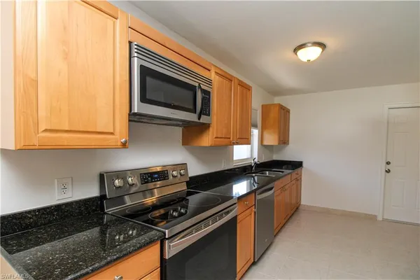 a kitchen with stainless steel appliances granite countertop a stove and a microwave