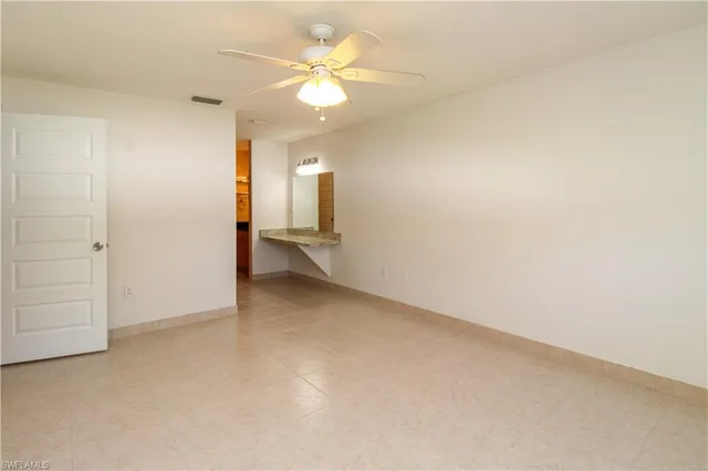an empty room with closet and a ceiling fan