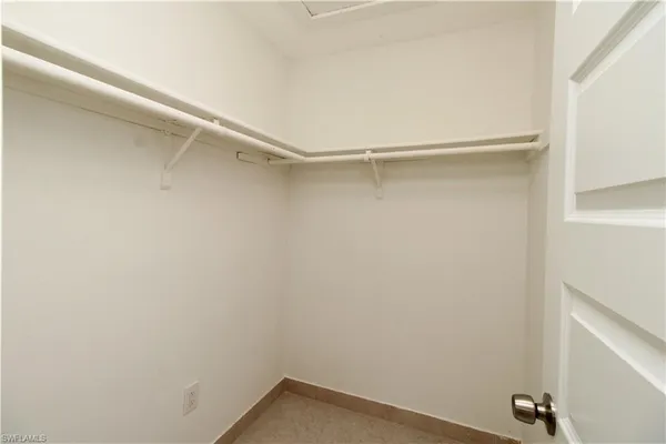 an empty room with a window and a ceiling fan