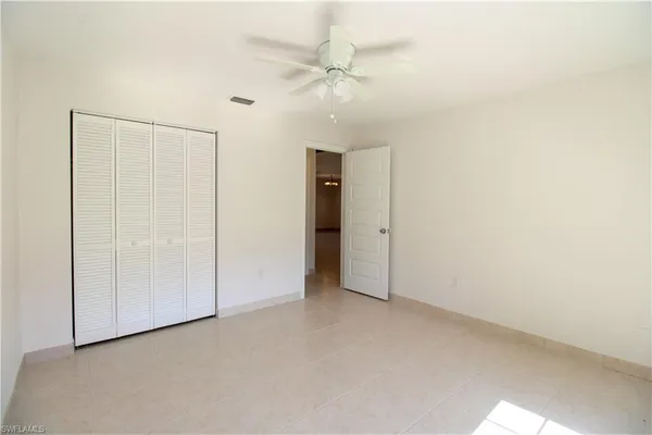 an empty room with fan and entryway