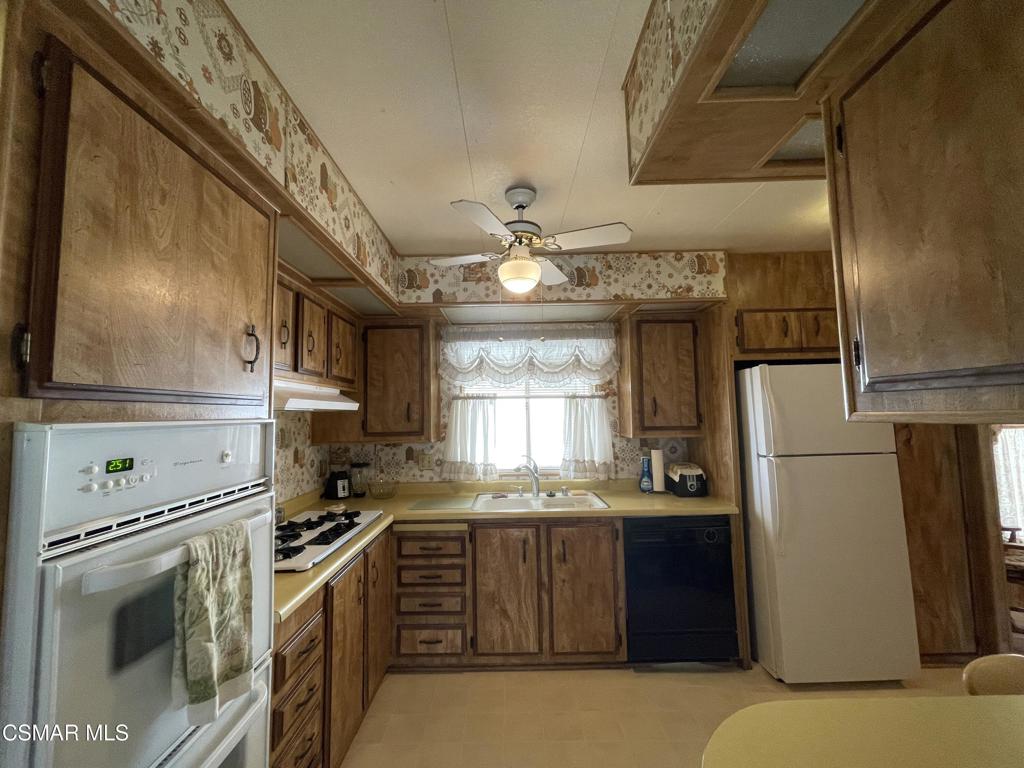 6480 Katherine Road, Unit 79 Simi Valley, CA 93063 - Photo 12 of 40 a kitchen with stainless steel appliances granite countertop a refrigerator a sink dishwasher a stove and white countertops with wooden floor
