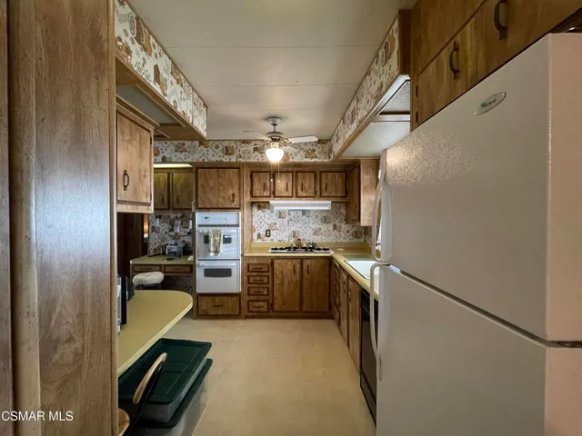 a kitchen with stainless steel appliances granite countertop a refrigerator and a stove