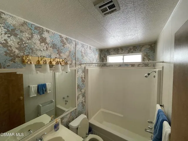 a bathroom with a shower a sink and a toilet