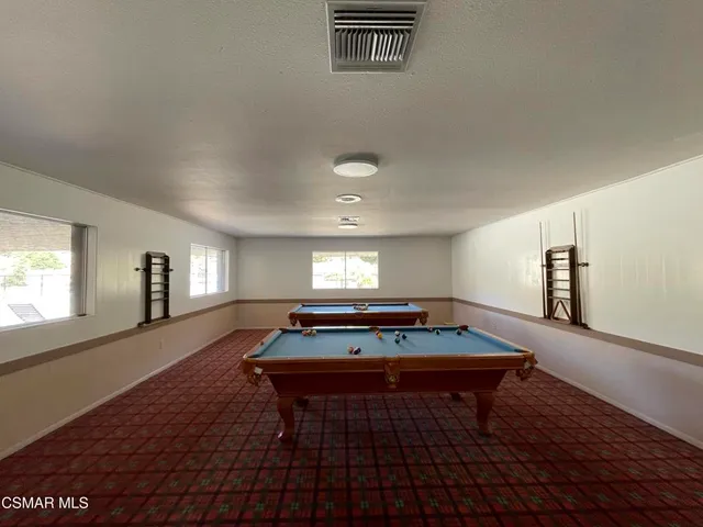 a room with pool table and windows