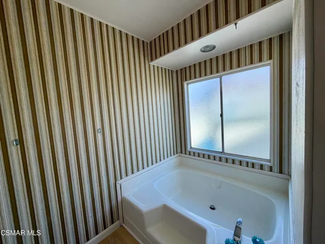 a hallway with wooden floor and chandelier