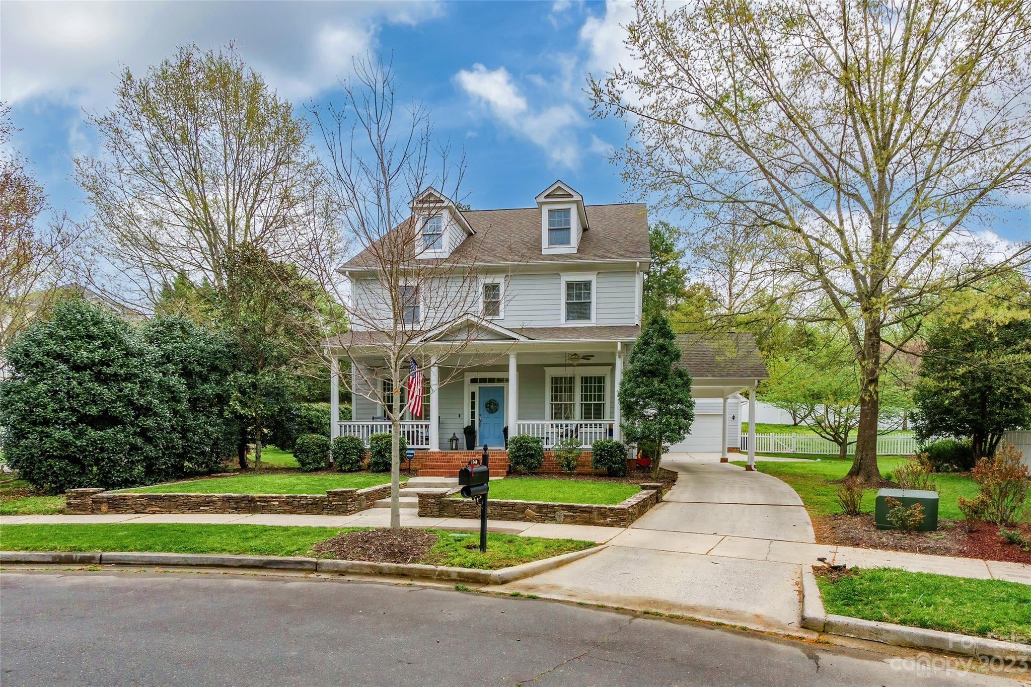 a front view of a house with a yard and trees