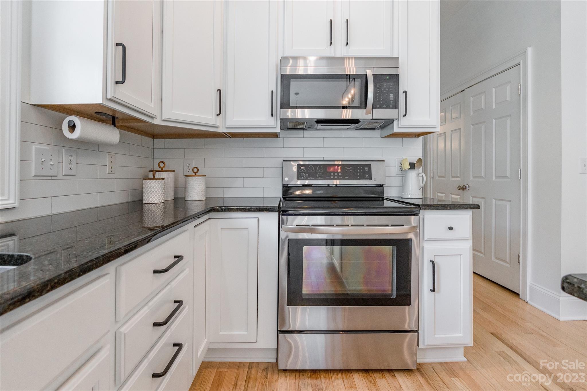 1744 Catherine Lothie Way Fort Mill, SC 29708 - Photo 17 of 44 a kitchen with stainless steel appliances granite countertop a stove a microwave and a white cabinets