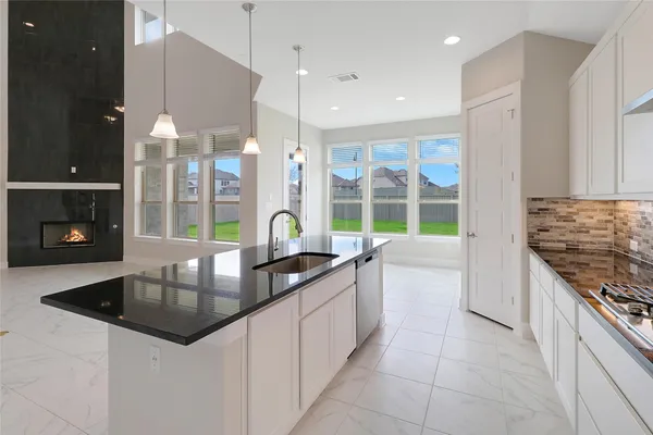 a kitchen with granite countertop a sink a counter top space appliances and cabinets