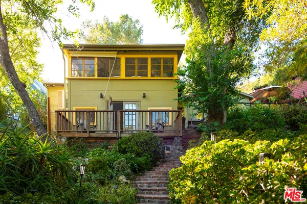 a view of a house with brick walls and flower plants