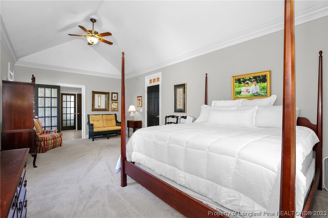 1145 Burning Tree Road Pinehurst, NC 28374 - Photo 20 of 45 a bedroom with a bed and a chandelier