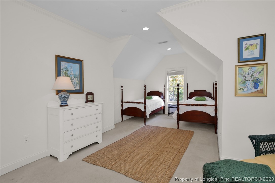 1145 Burning Tree Road Pinehurst, NC 28374 - Photo 27 of 45 a bedroom with furniture and a lamp