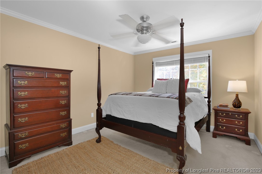 1145 Burning Tree Road Pinehurst, NC 28374 - Photo 29 of 45 a bedroom with a bed a chandelier and a window