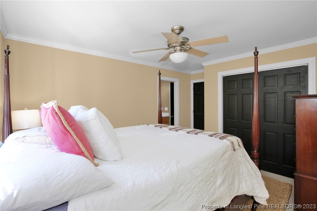 1145 Burning Tree Road Pinehurst, NC 28374 - Photo 30 of 45 a bedroom with a bed and a chandelier