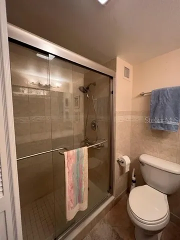 a bathroom with a toilet and a shower