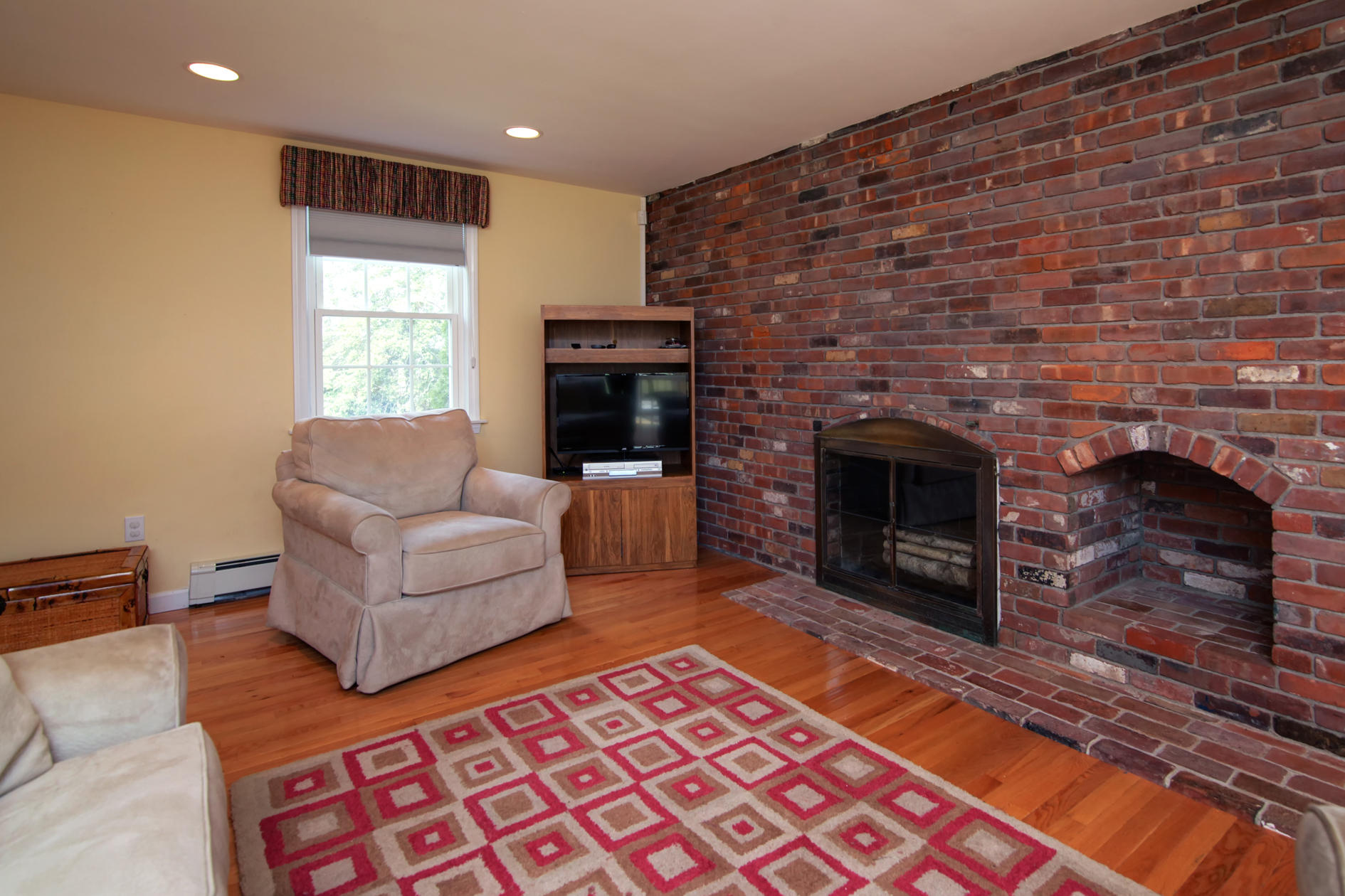 115 Holly Point Road Centerville, MA 02632 - Photo 11 of 26 a living room with furniture a flat screen tv and a fireplace