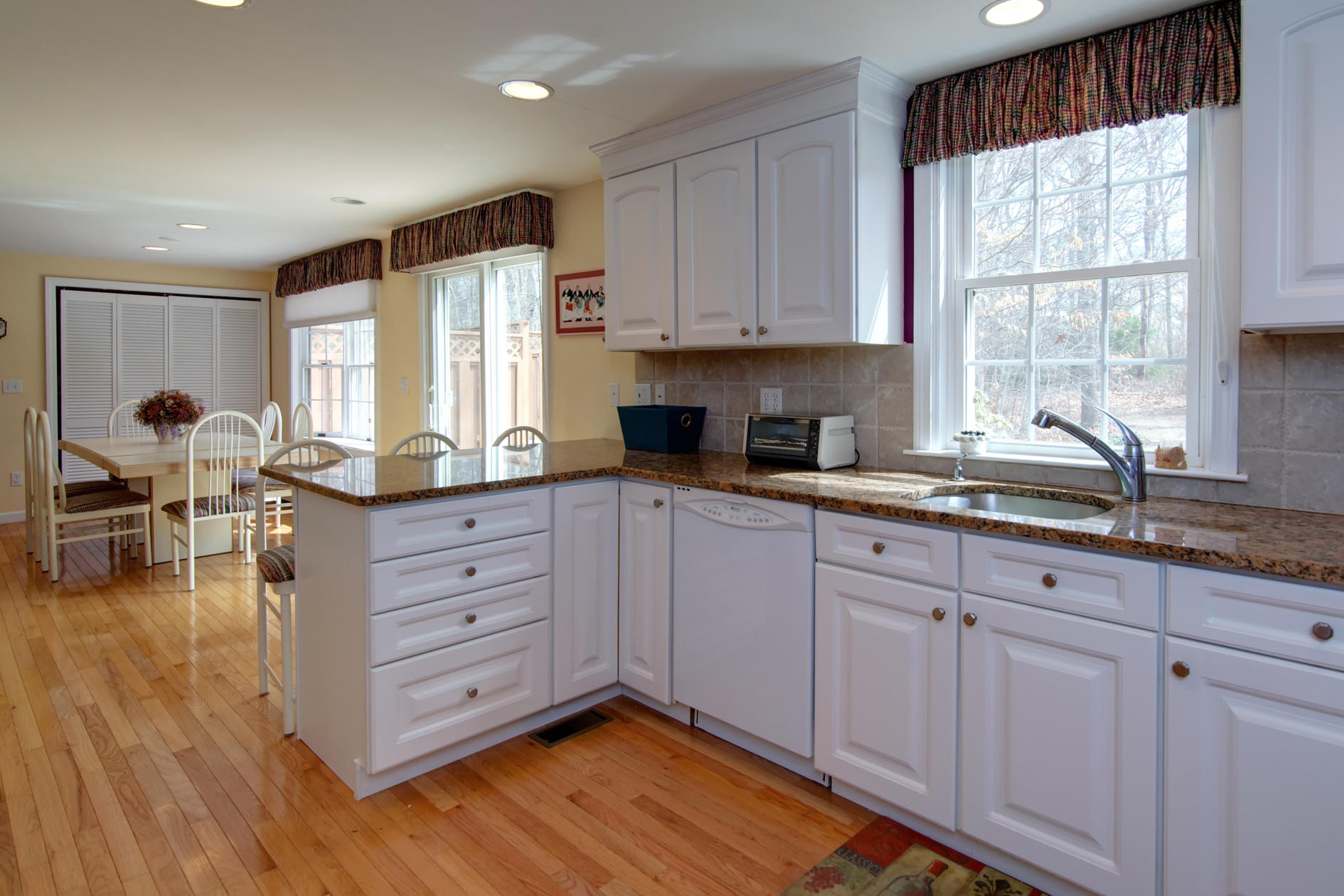 115 Holly Point Road Centerville, MA 02632 - Photo 19 of 26 a kitchen with sink cabinets and wooden floor