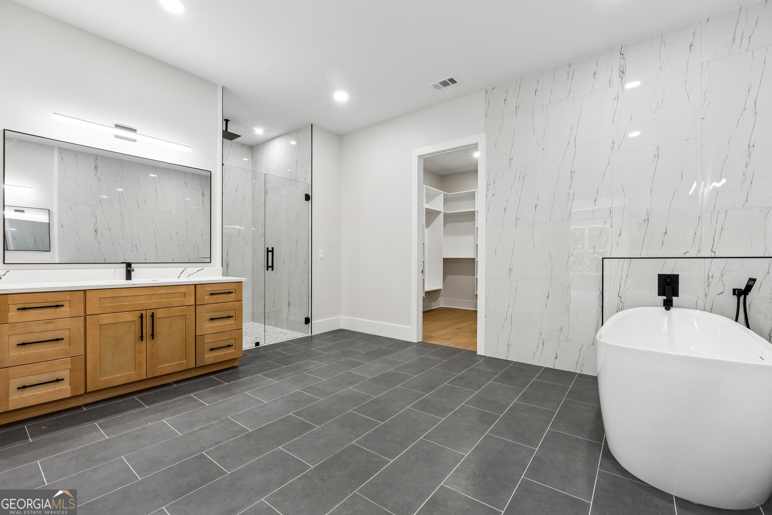 1622 Double Springs Monroe, GA 30656 - Photo 23 of 44 a spacious bathroom with a double vanity sink a mirror and a bathtub