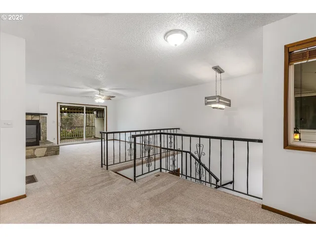 a view of an empty room with window and fireplace
