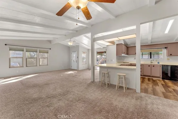 a large white kitchen with a sink and chairs